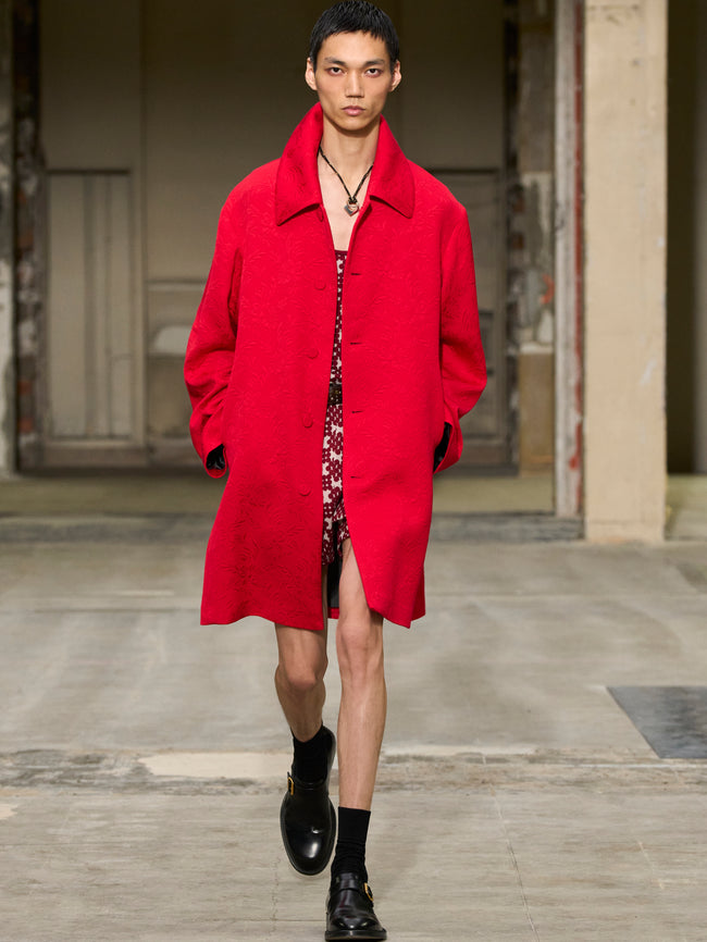 Model wearing a red coat on a runway - Dries Van Noten