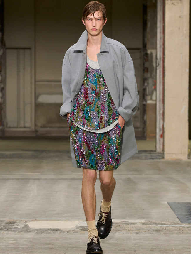 Model wearing a floral dress and gray coat on a runway - Dries Van Noten