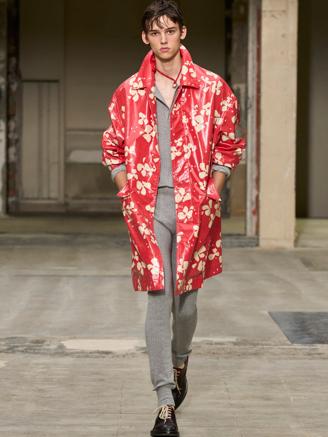 Model wearing a red floral coat on a runway - Dries Van Noten