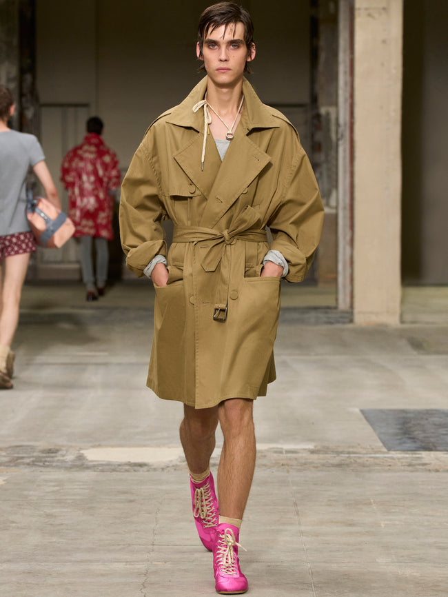 Model walking on a runway wearing a beige trench coat and pink shoes. - Dries Van Noten