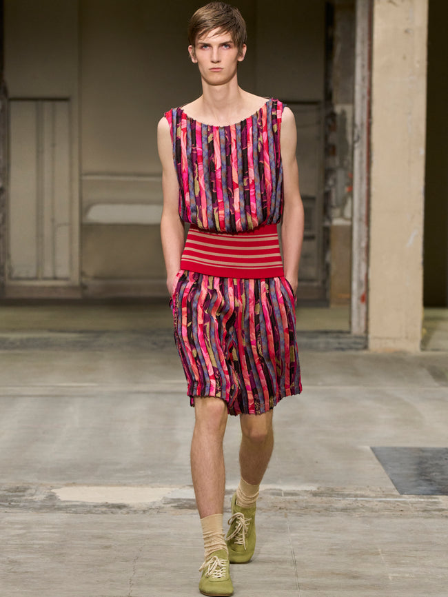 Model wearing a colorful striped outfit on a runway. - Dries Van Noten
