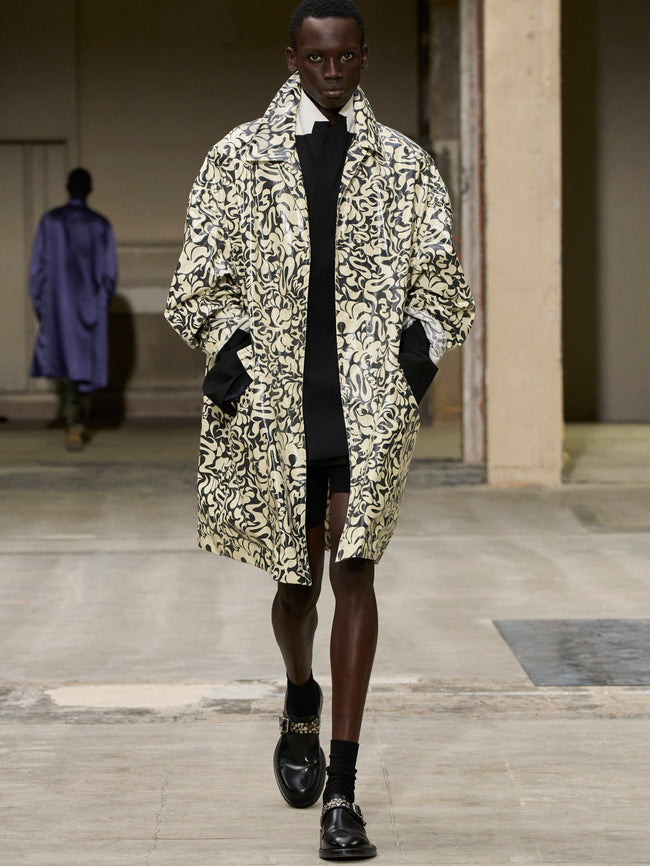 Model wearing a patterned coat on a runway - Dries Van Noten
