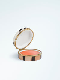 Round lip balm compact featuring a striped case