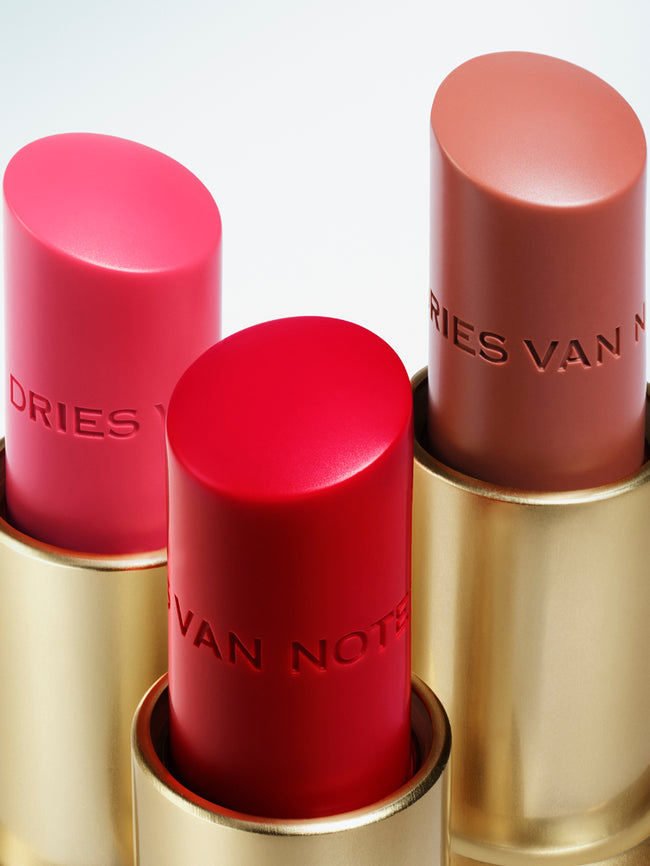 Three lip balm bullets on light blue background.