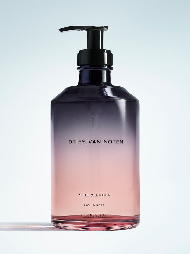Gradient liquid soap bottle with pump from black to pink, featuring 'Dries Van Noten' branding.