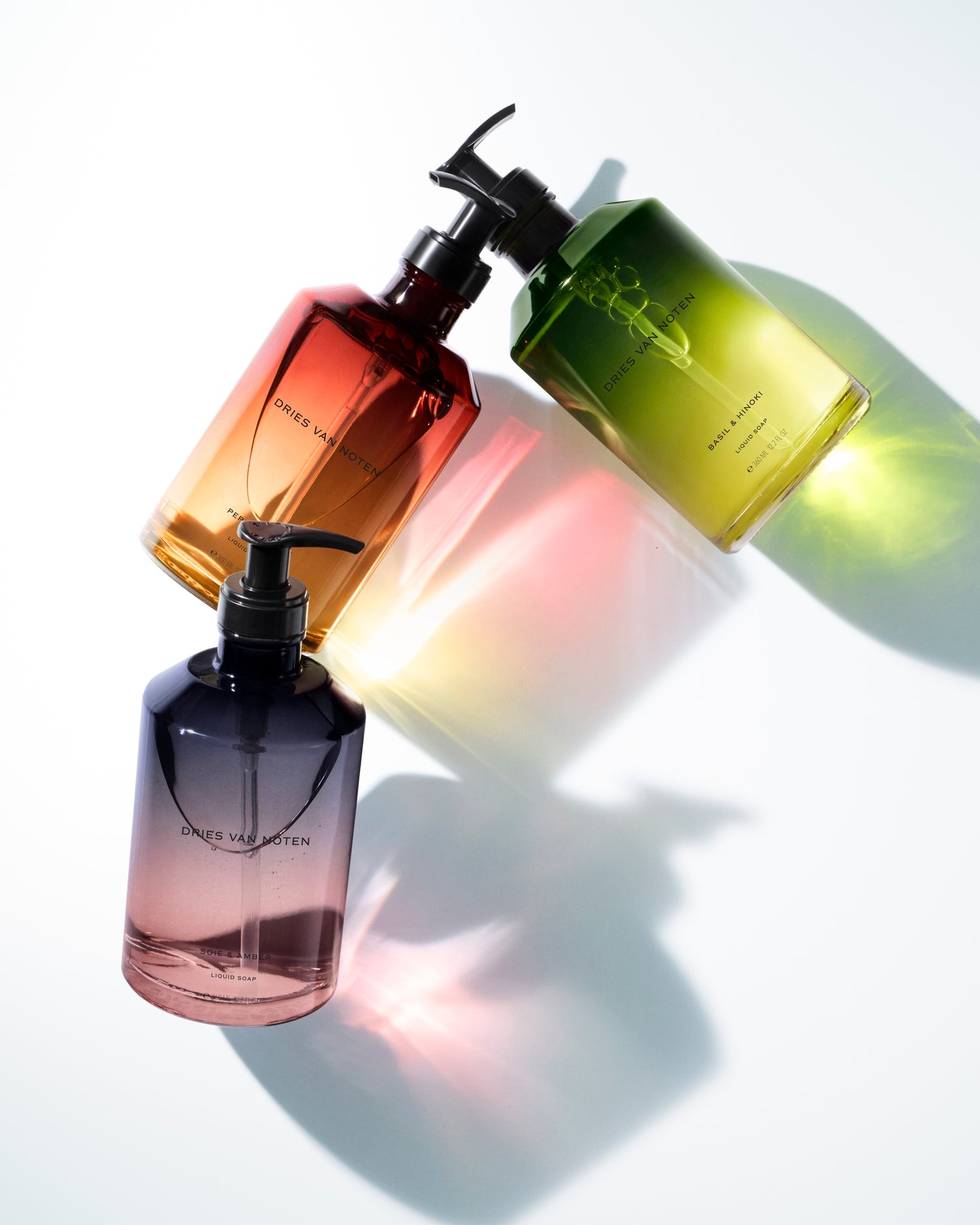 Three colored pump bottles arranged diagonally on a white background.