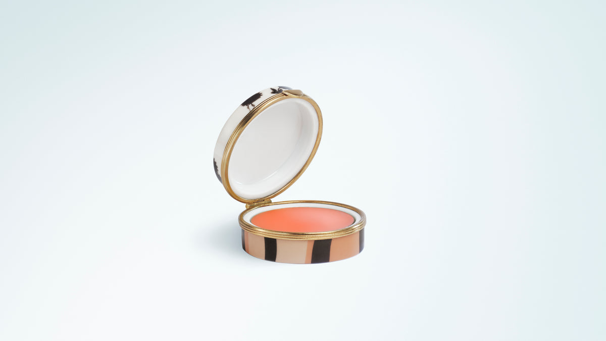 Round lip balm compact featuring a striped case