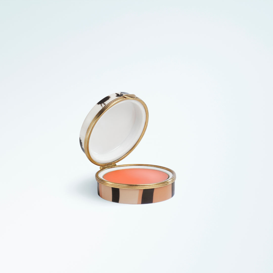 Round lip balm compact featuring a striped case