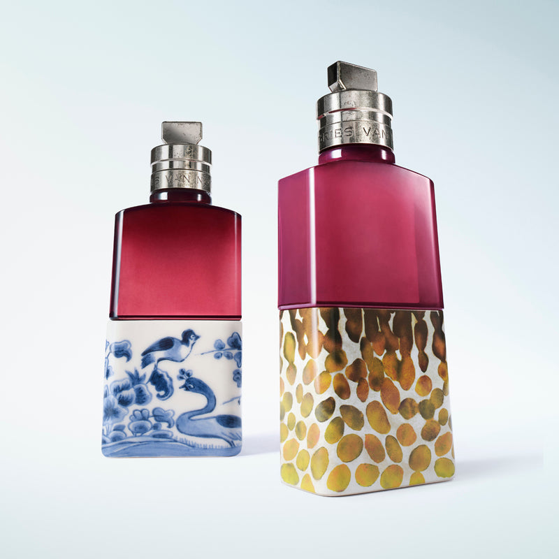 Two fragrance bottles, one featuring a blue and white wave pattern base and the other a textured gold base, set against a light blue gradient background.