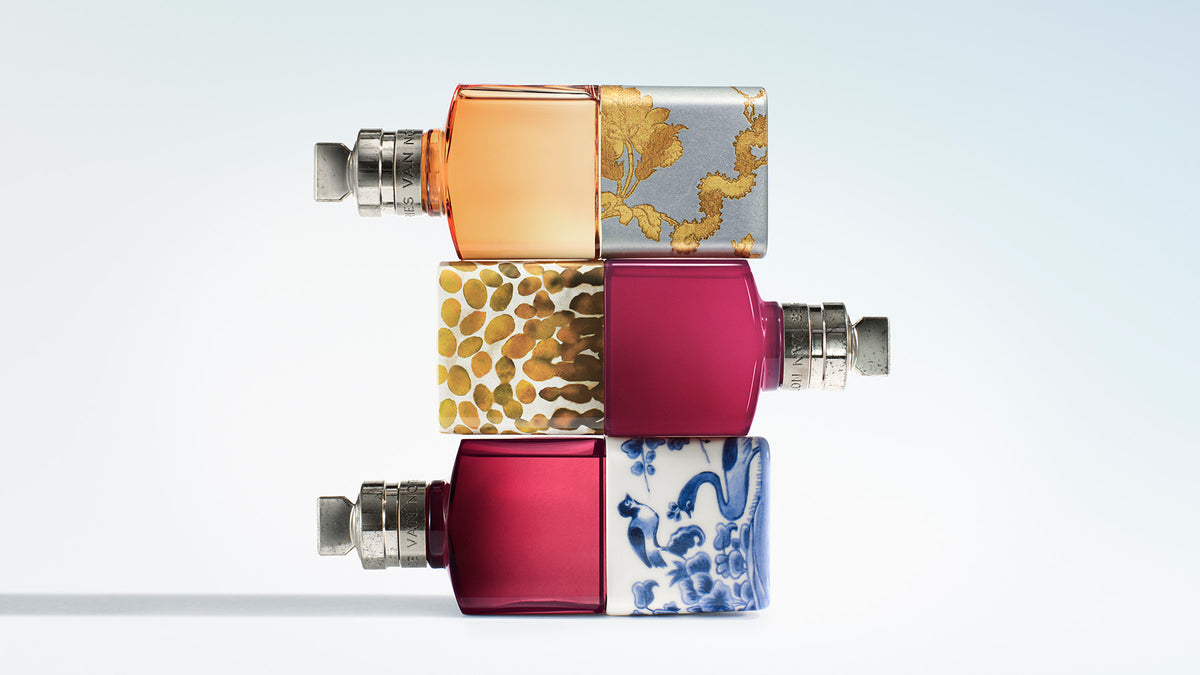 Three fragrance bottles stacked on a light blue gradient background.