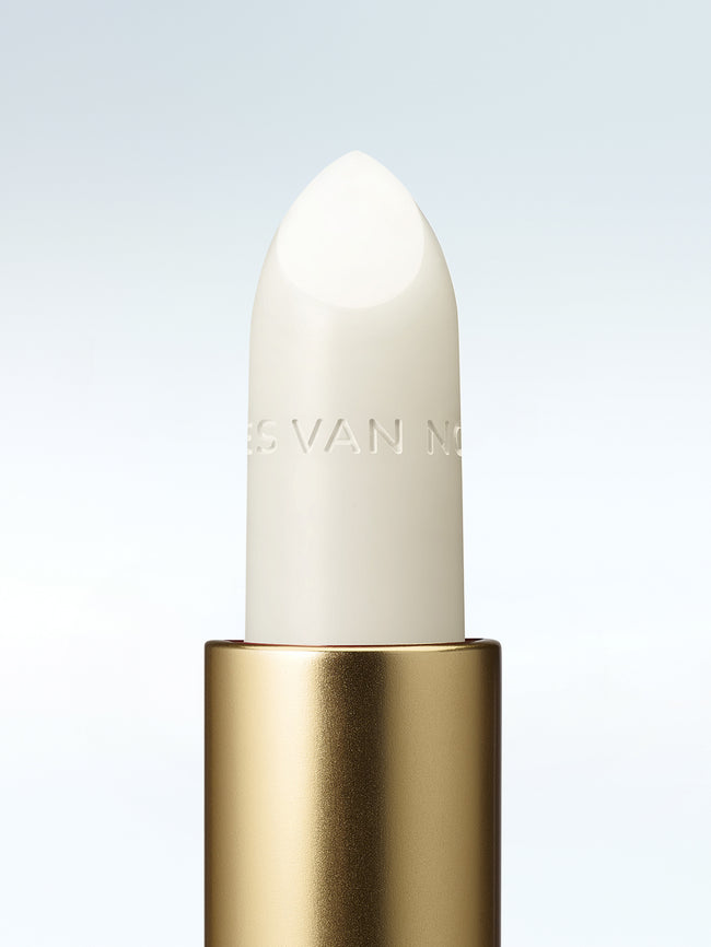 Close-up of a Dries Van Noten balm in a gold tube against a clean white background 