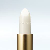 Close-up of a Dries Van Noten balm in a gold tube against a clean white background 