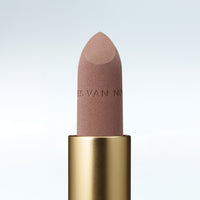 Close-up of a Dries Van Noten lipstick in a gold tube against a cold white background