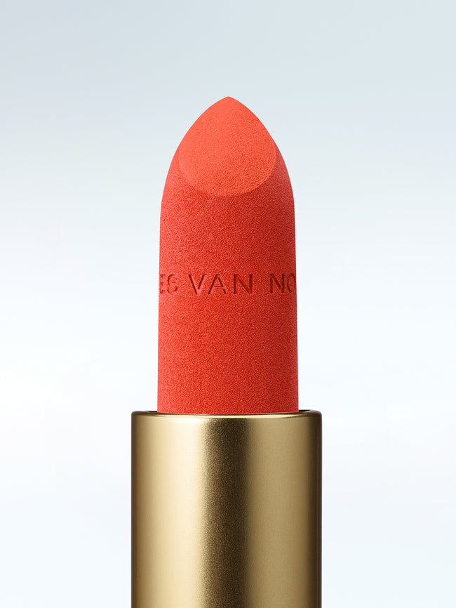 Close-up of a Dries Van Noten lipstick in a gold tube against a cold white background
