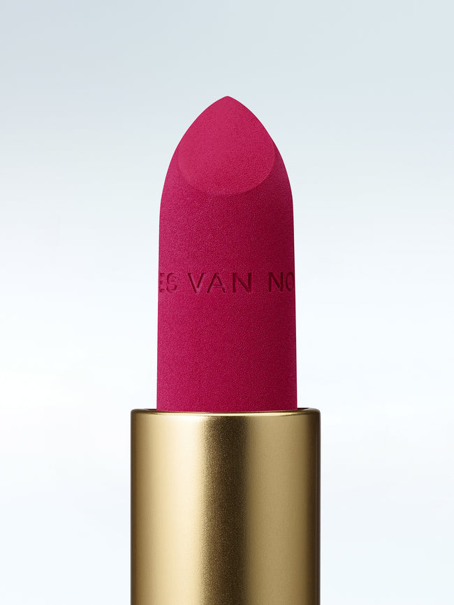 Close-up of a Dries Van Noten lipstick in a gold tube against a cold white background