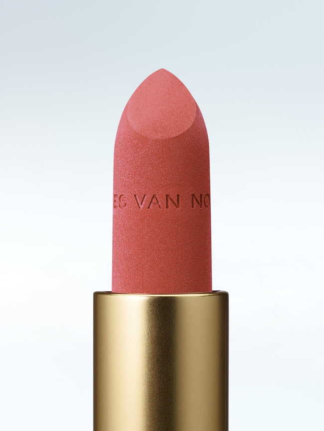 Close-up of a Dries Van Noten lipstick in a gold tube against a cold white background