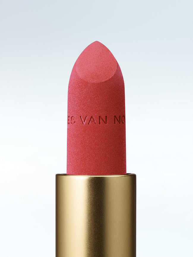 Close-up of a Dries Van Noten lipstick in a gold tube against a cold white background