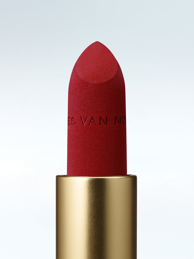 Close-up of a Dries Van Noten lipstick in a gold tube against a cold white background