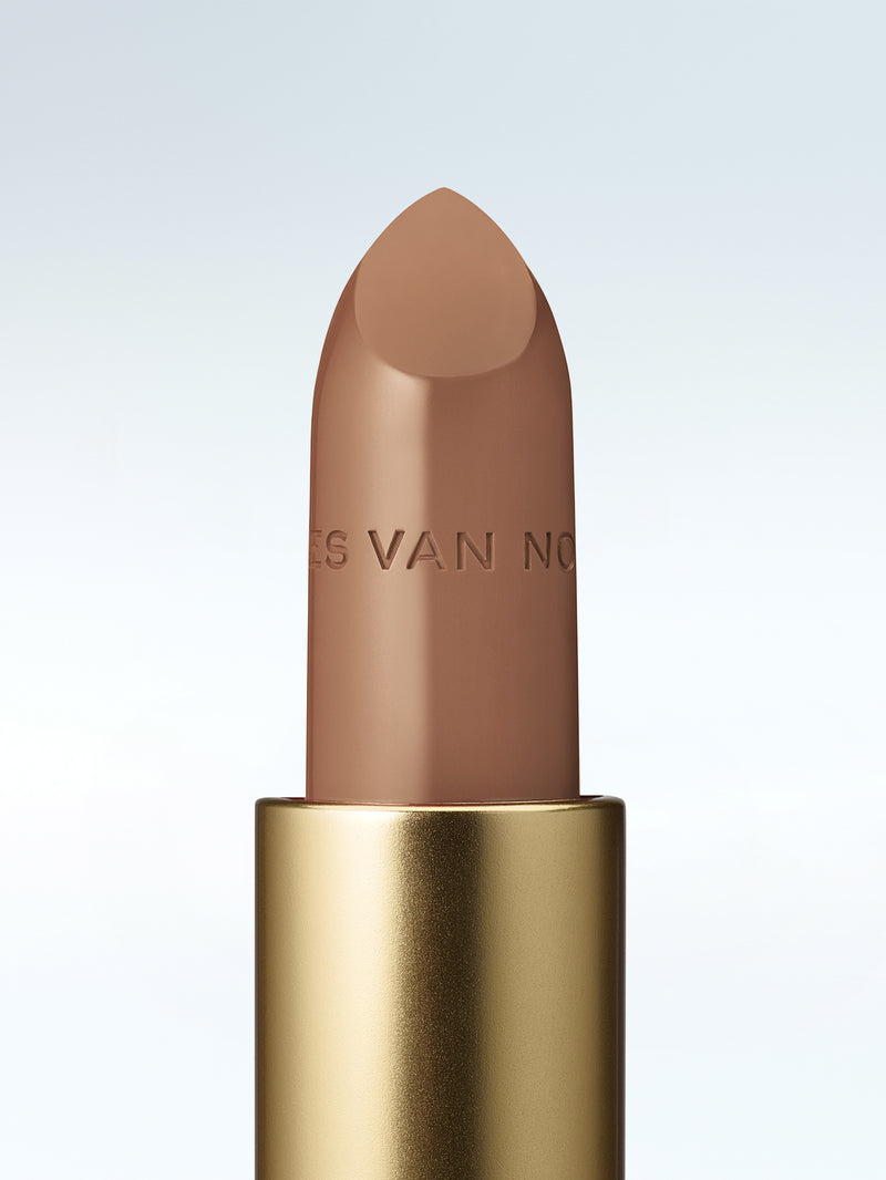 Close-up of a Dries Van Noten lipstick in a gold tube against a cold white background