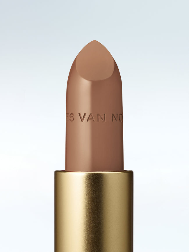 Close-up of a Dries Van Noten lipstick in a gold tube against a cold white background