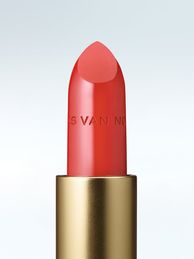Close-up of a Dries Van Noten lipstick in a gold tube against a cold white background