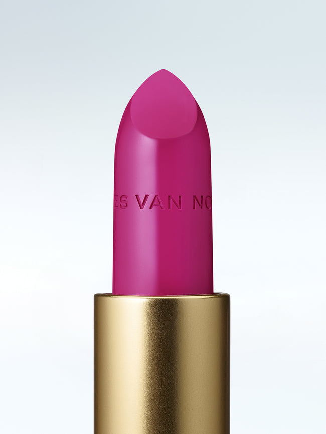 Close-up of a Dries Van Noten lipstick in a gold tube against a cold white background