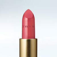 Close-up of a Dries Van Noten lipstick in a gold tube against a cold white background