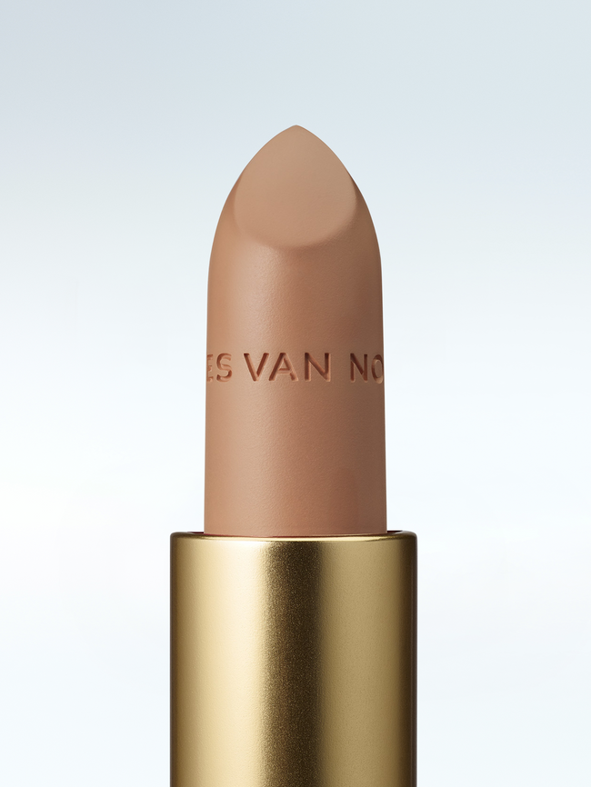 Close-up of a Dries Van Noten lipstick in a gold tube against a cold white background