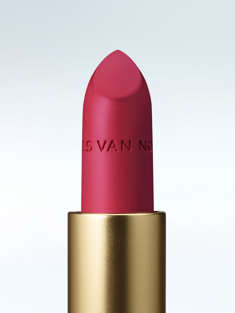 Close-up of a Dries Van Noten lipstick in a gold tube against a cold white background 