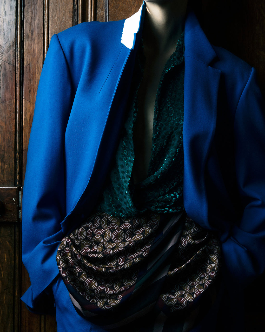 Blue blazer over a patterned dress on a wooden door background
