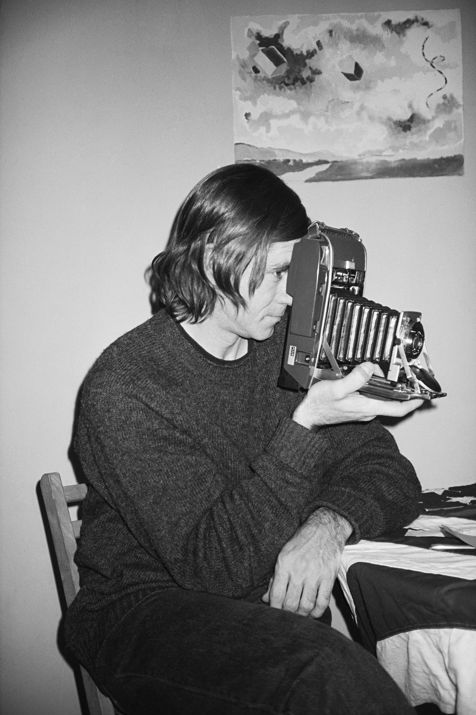 black and white portrait of a man holding a camera