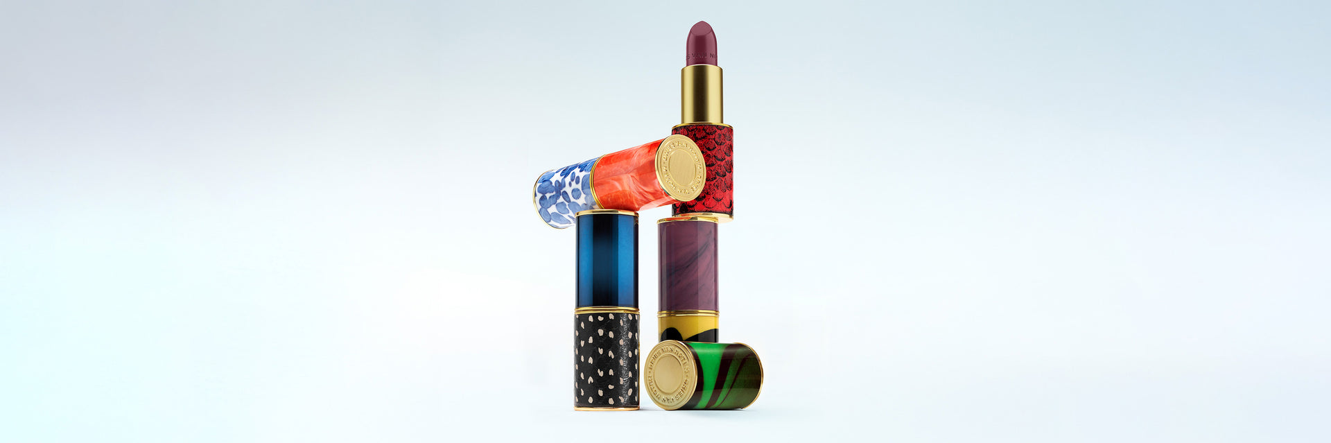 Colorful lipstick and nail polish set on a light gray background - Dries Van Noten