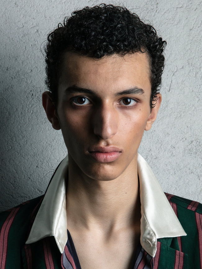 Person wearing a striped shirt with a plain background