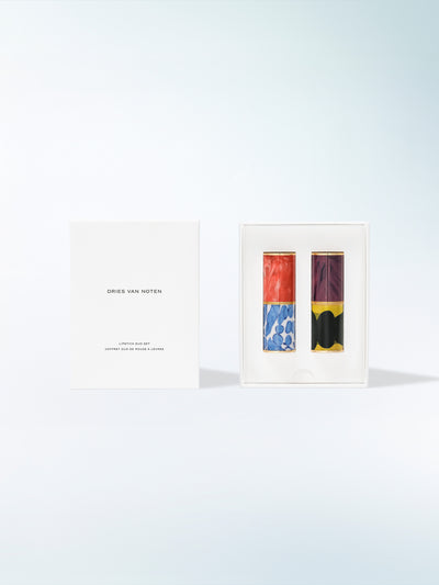 A open box that contains two lipstick cases on a light blue background - Dries Van Noten