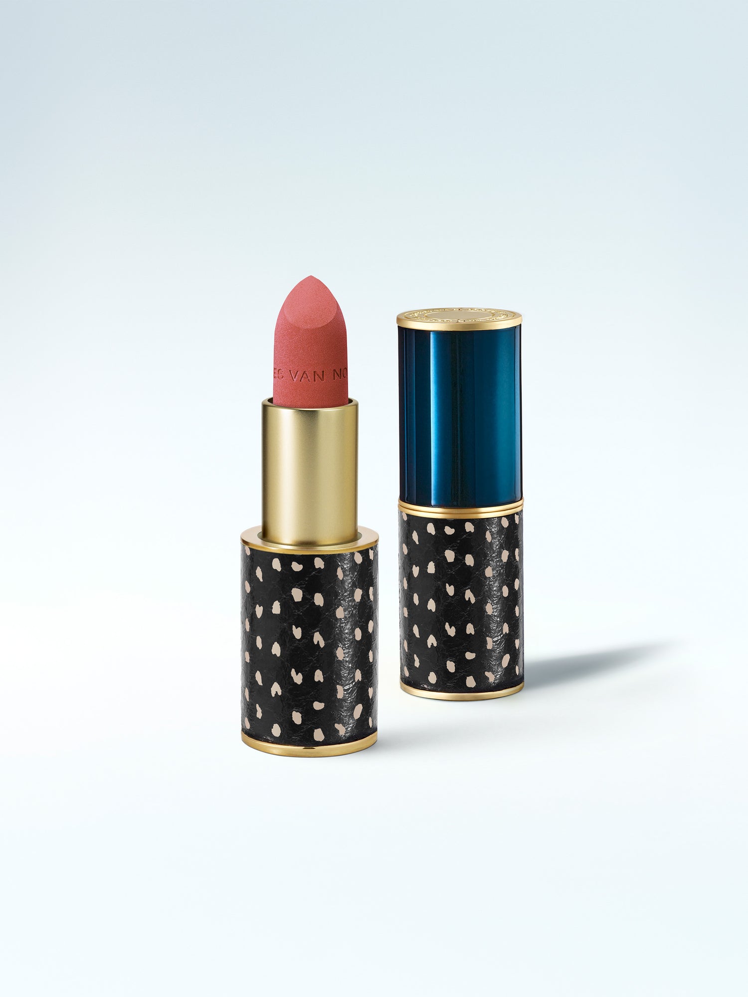 Lipstick with black case featuring gold polka dots on a white background