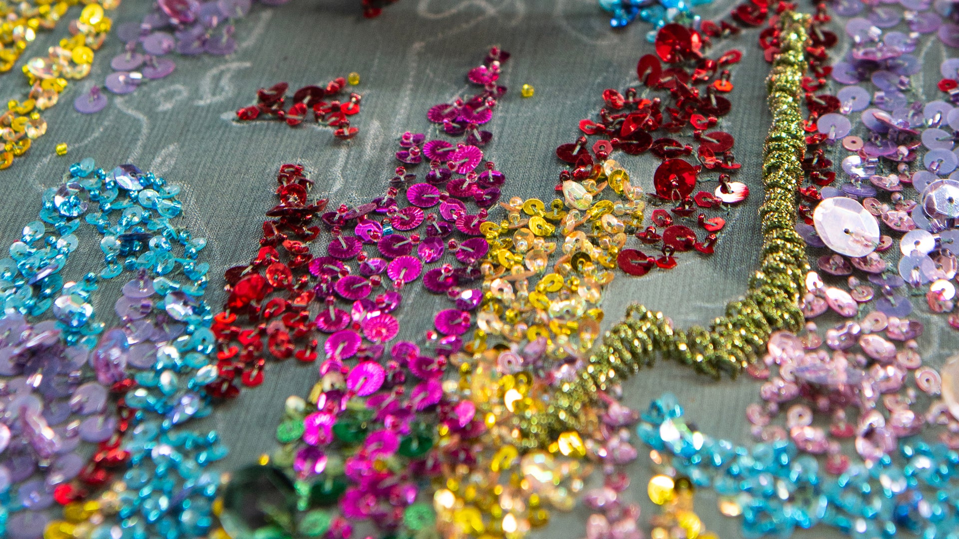 Close-up of colorful sequins on a see-through fabric background