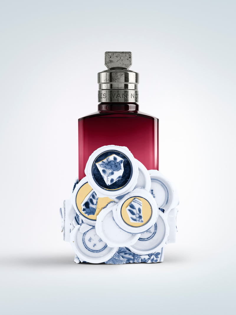 Perfume bottle with decorative cap on a light gray background - Dries Van Noten