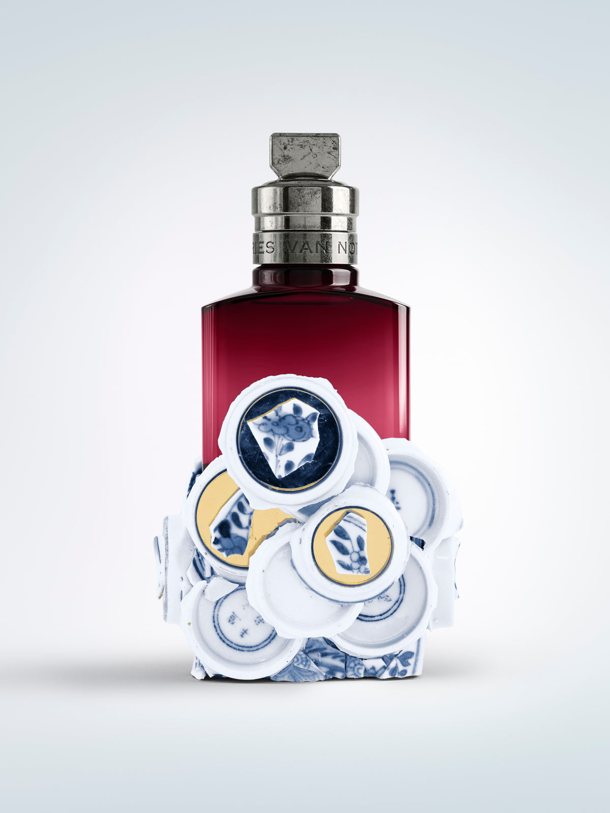 Perfume bottle with decorative cap on a light gray background - Dries Van Noten