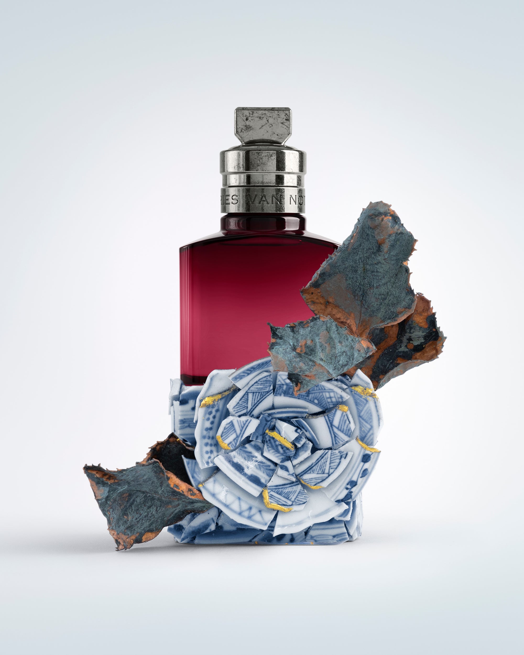 Perfume bottle with decorative elements on a light gray background - Dries Van Noten