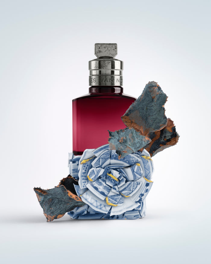 Perfume bottle with decorative elements on a light gray background - Dries Van Noten
