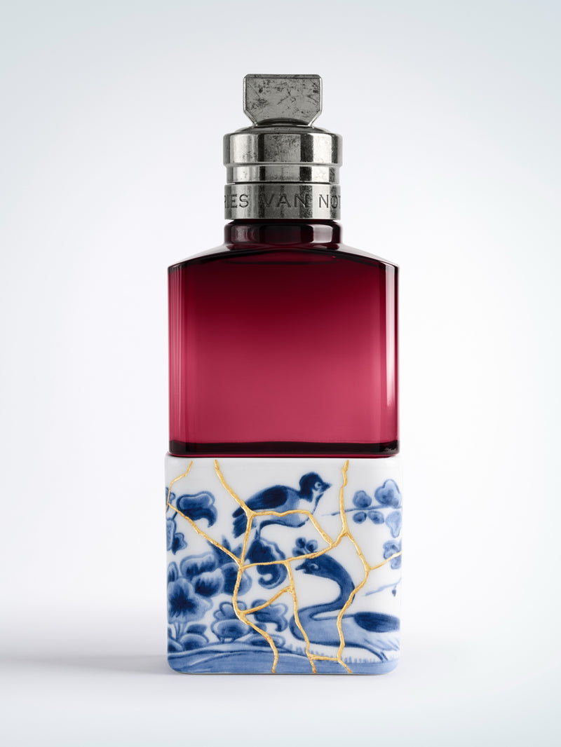 Perfume bottle with decorative label on a white background - Dries Van Noten