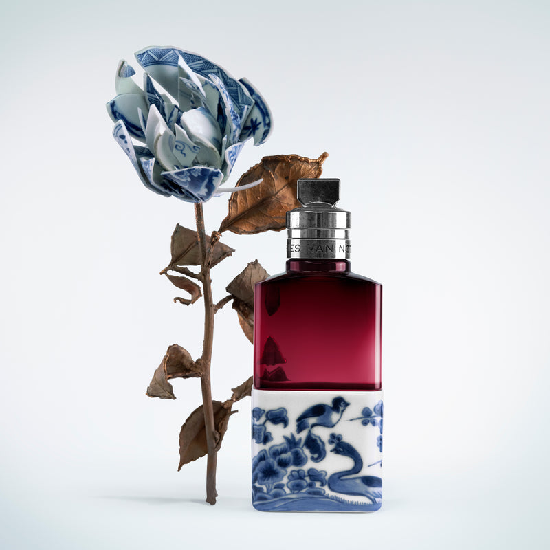 Perfume bottle with decorative blue and white design on a white background - - Dries Van Noten