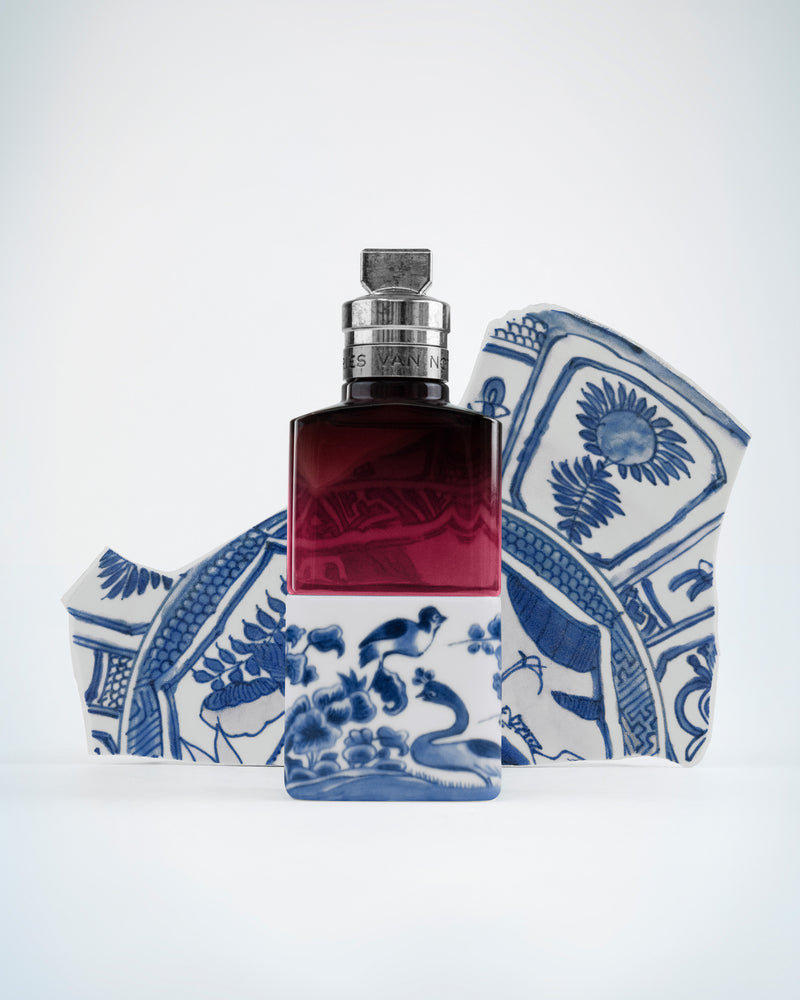 Perfume bottle with blue and white patterned box on a light gray background - Dries Van Noten