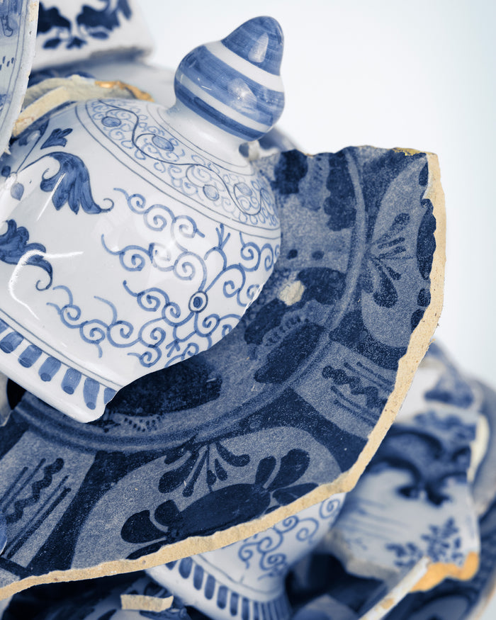 Blue and white ceramic pieces with intricate patterns on a white  background - Dries Van Noten