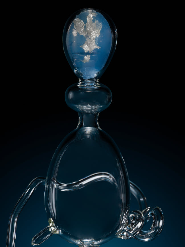 Glass sculpture with reflective surface on a black background