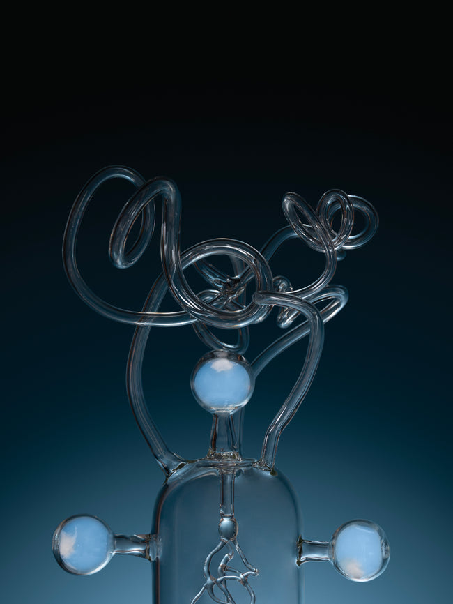 Glass sculpture of a figure with a dark blue background