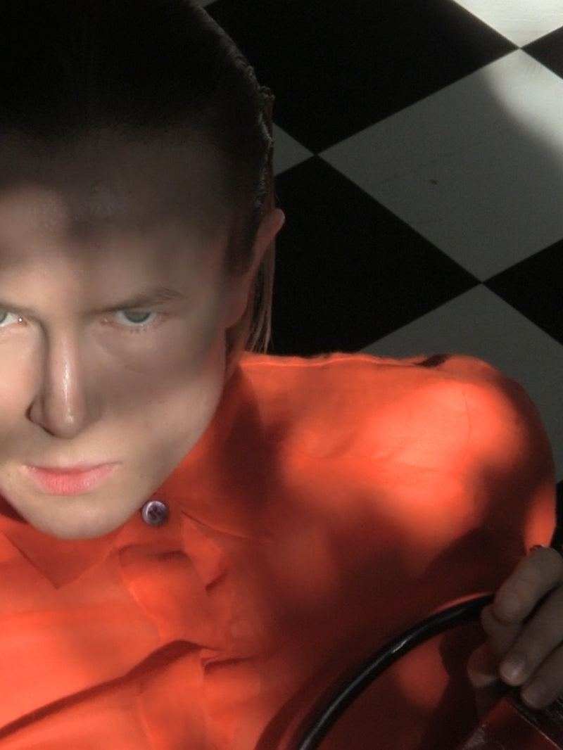Person wearing an orange shirt with a checkered background