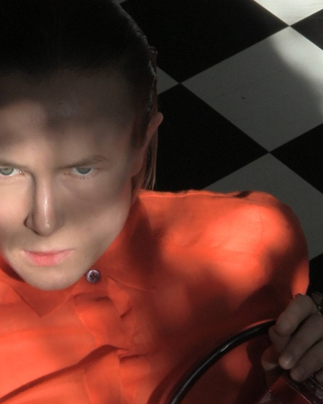 Person wearing an orange shirt with a checkered background