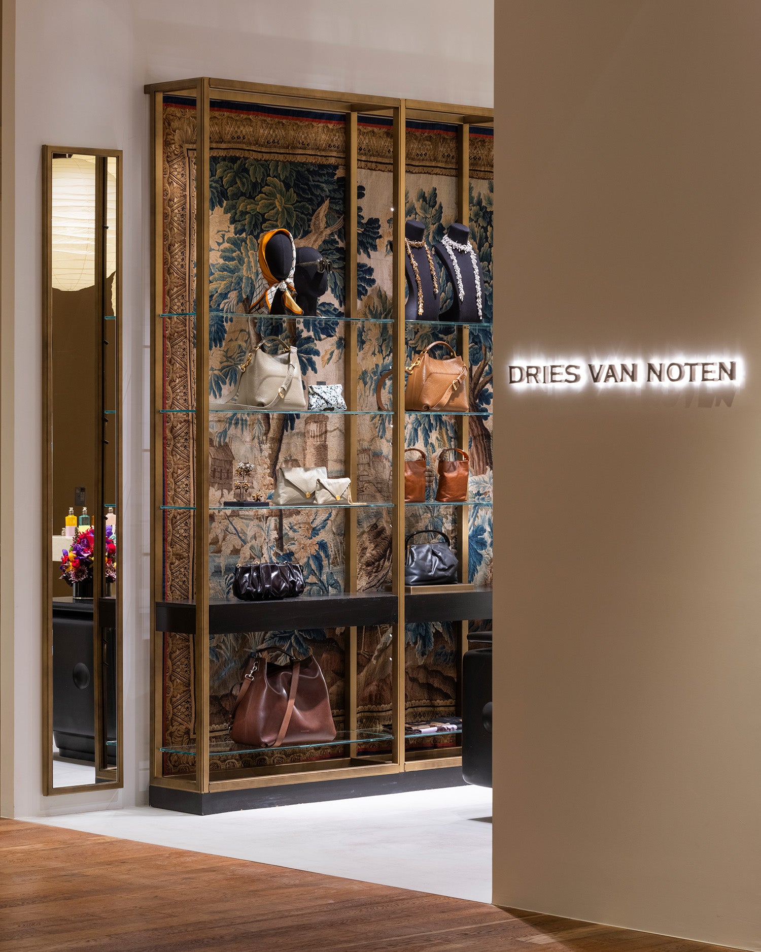 A luxury display cabinet filled with designer handbags, set in a high-end boutique Dries Van Noten.