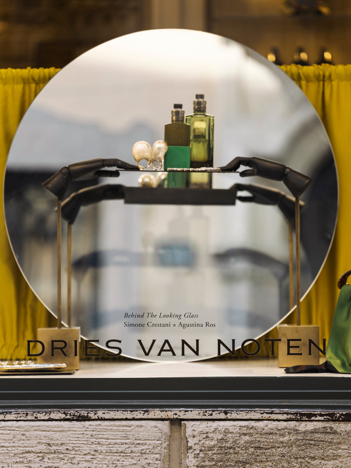 Dries Van Noten display with perfume bottles and a mirror